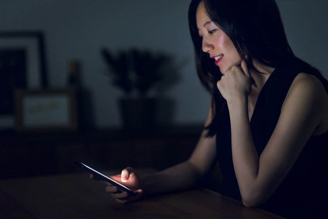 A woman uses a mobile device to conduct online banking