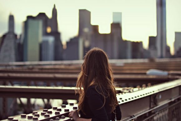 A woman gazes upon a city skyline